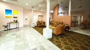A spacious lobby with marble flooring, two sofas, a console table with potted plants, and a chandelier. - Days Inn by Wyndham Portland/Corpus Christi (Portland)