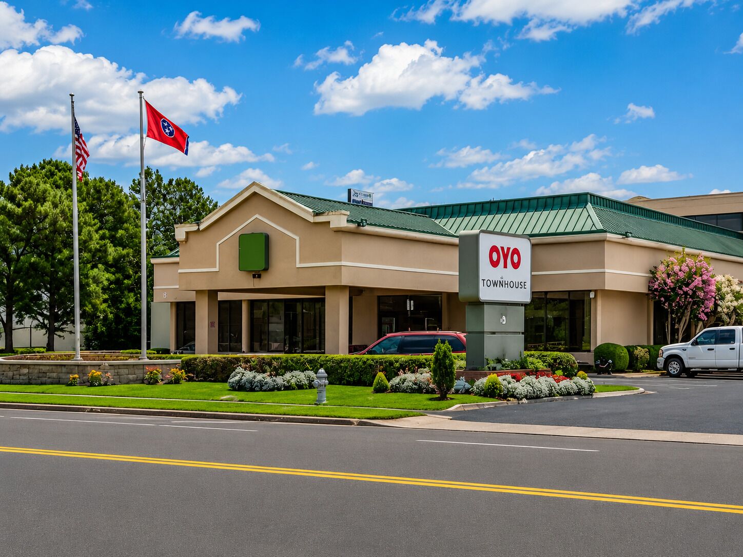 A building with a sign reading 'OYO TOWNHOUSE' and a flagpole with an American flag.