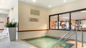 Et spaområde med jacuzzi, træningsudstyr og et skilt, der angiver en maksimal spakapacitet på 6 personer.