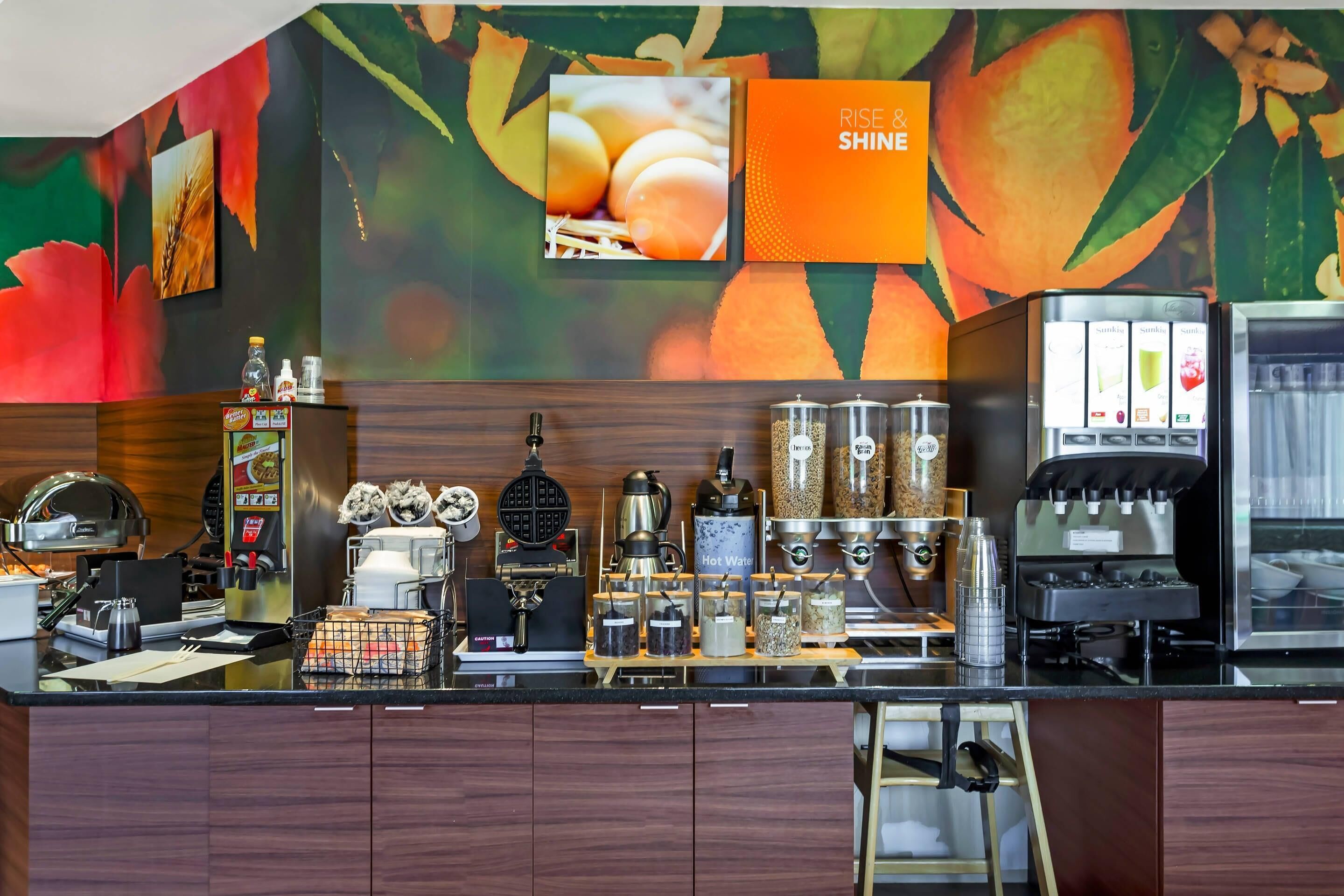A kitchen area with a coffee machine, a waffle maker, and various containers.