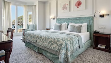 Habitación de hotel con una cama grande, una silla, una mesa y vistas al exterior.