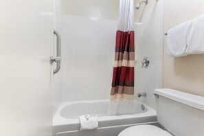 A bathroom with a bathtub, toilet, and shower curtain. - Red Roof Inn Lafayette - Purdue University (Lafayette)