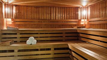 A sauna with wooden benches and benches, and a bench with towels.