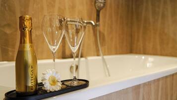 A champagne bottle and two glasses on a tray in a bathroom setting.