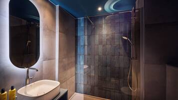 Un baño moderno con un espejo grande, una bañera y una ducha.