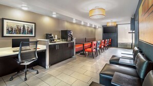 A modern hotel lobby with a reception desk, seating area, and a large framed cityscape artwork. - Best Western Charlotte-Gastonia (Gastonia)