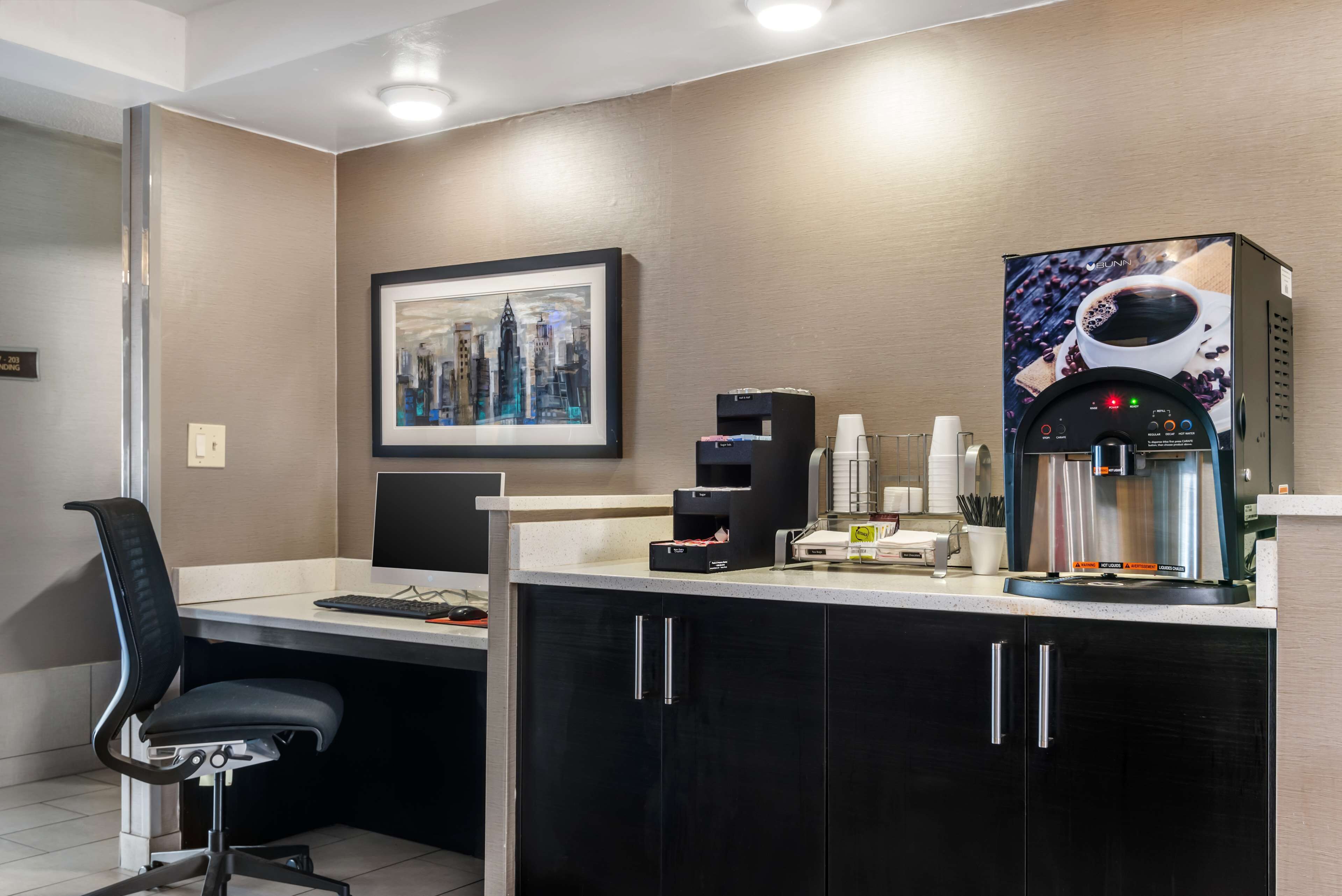 Un espacio de oficina moderno con un escritorio, una silla y una máquina de café.