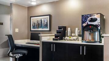 A modern office space with a desk, chair, and a coffee machine.