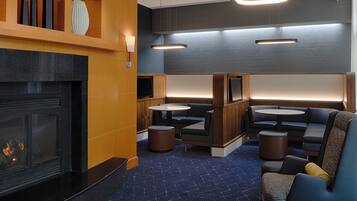 A modern lounge area with a fireplace, seating, and ambient lighting.