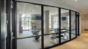 A modern gym with exercise equipment, large windows, and a clean, well-lit interior. - Courtyard by Marriott Springfield Downtown (Springfield)