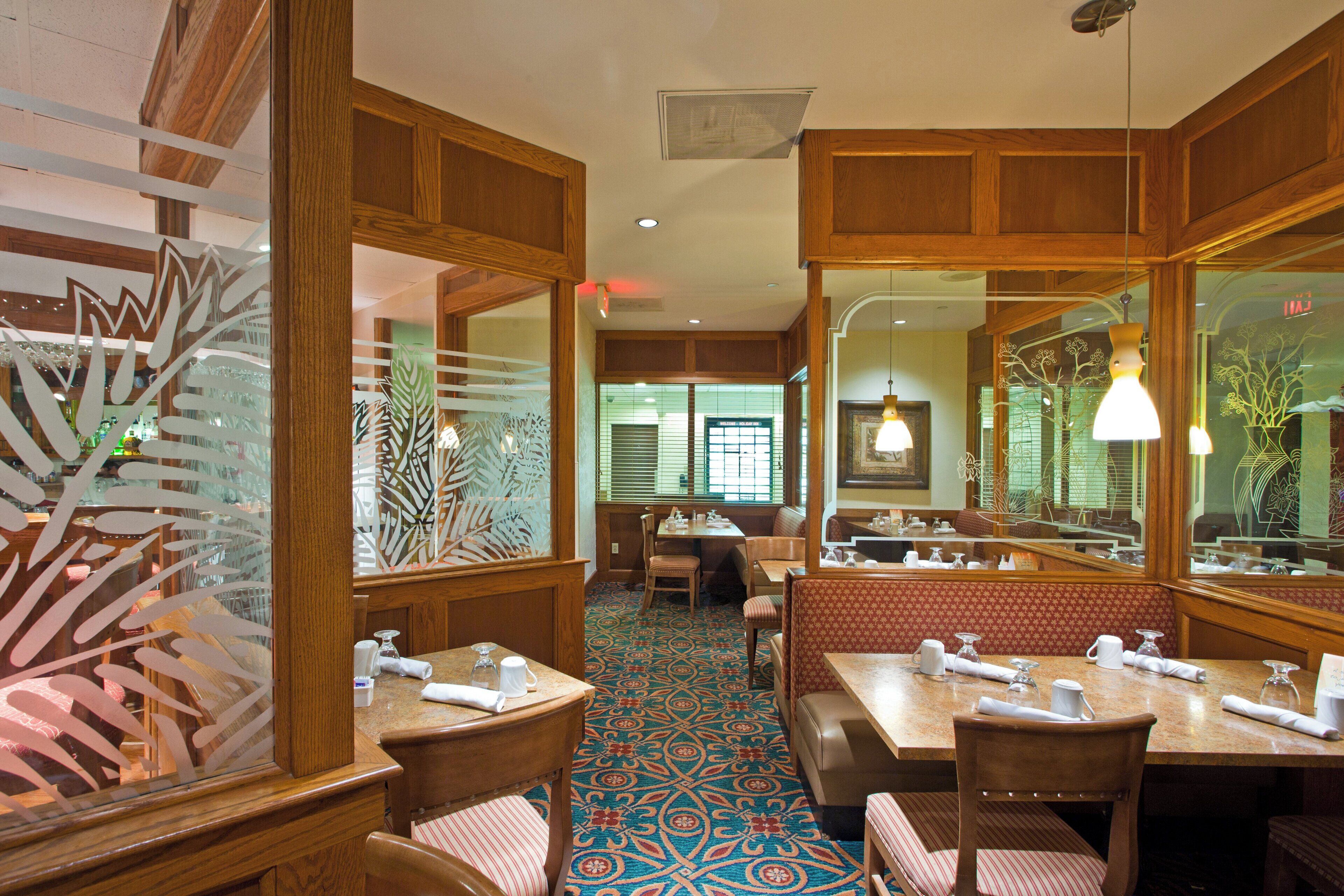 A restaurant interior with wooden paneling, patterned carpet, and mirrored walls.