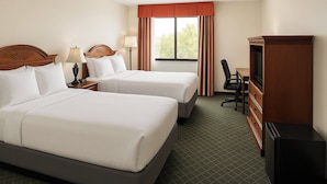 A hotel room with two beds, a desk with a chair, a television, and a dresser. - Holiday Inn Port St. Lucie by IHG (Port Saint Lucie)