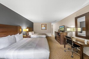 A hotel room with two beds, a desk, a chair, a television, and a mirror.