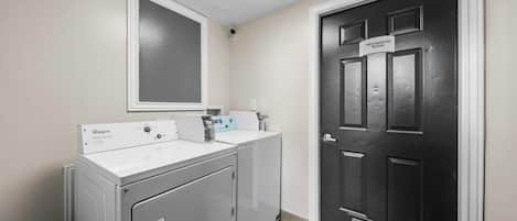 A laundry room with a Whirlpool washer and dryer, a mirror, and a door labeled 'Mechanical Room.'
