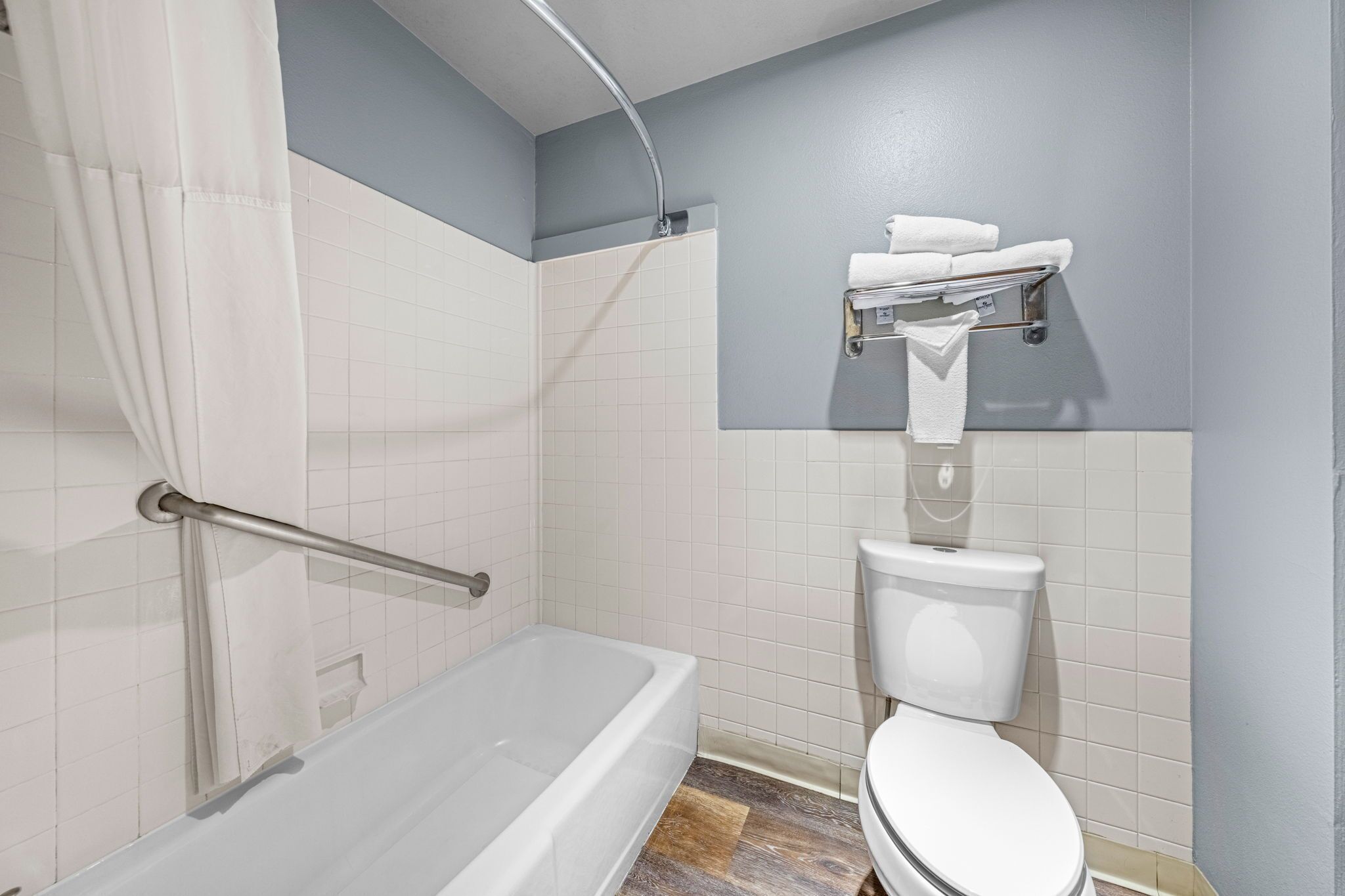 A bathroom with a bathtub, toilet, and a shower curtain.