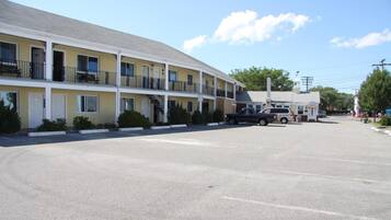 A motel with a two-story structure, a parking lot, and a small adjacent building.