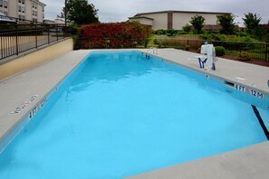 Una piscina al aire libre de temporada, sombrillas