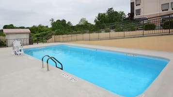 Una piscina al aire libre de temporada, sombrillas