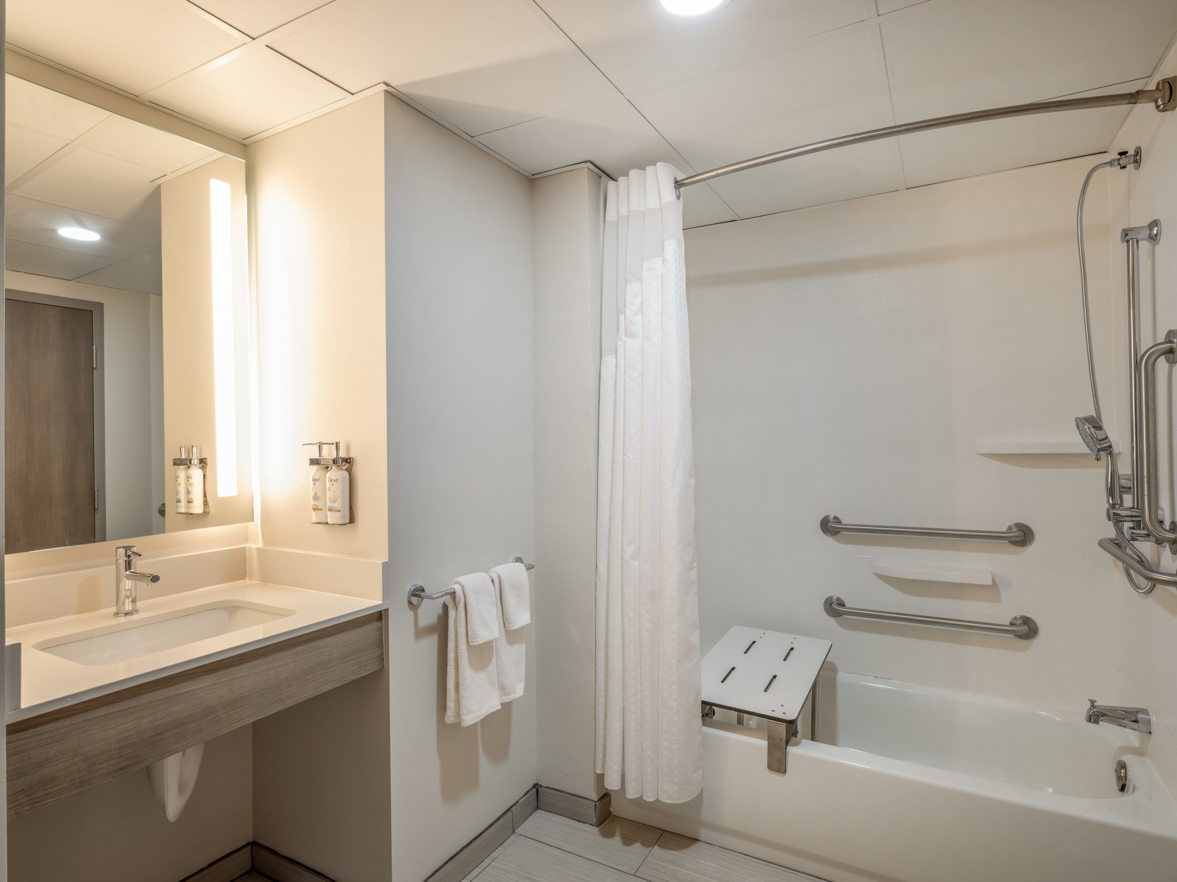 A modern bathroom with a bathtub, shower, and sink.