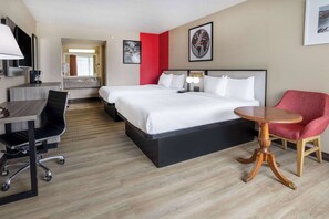 A hotel room with a bed, desk, chair, and a round wooden table. - Ramada by Wyndham Rome / Verona (Rome)