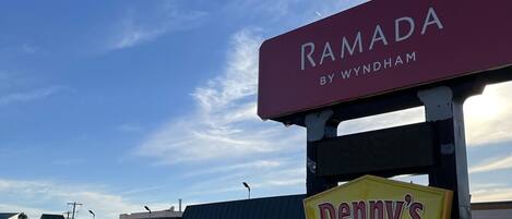 A parking lot with a building labeled "RAMADA BY WYNDHAM" and a "Denny's" sign.