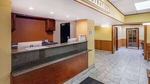 A reception area with a registration desk, a black door, and a sign above the desk. - Ramada by Wyndham Rome / Verona (Rome)