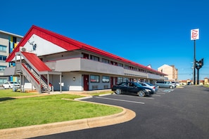 Ett motell med ett rött tak, ett överbyggt parkeringsområde och en skylt för Red Roof Inn.