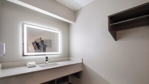 A modern bathroom with a large mirror, a sink, and a towel rack. - Red Roof Inn Chattanooga - Hamilton Place (Chattanooga)