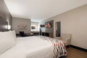 A hotel room with a large bed, a desk, a chair, a television, and a painting on the wall. - Red Roof Inn Chattanooga - Hamilton Place (Chattanooga)
