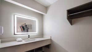 Casa de banho moderna com um espelho grande, lavatório e porta-toalhas.