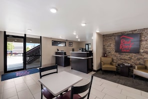 A modern interior with a reception desk, seating area, and a stone accent wall. - Red Roof Inn Chattanooga - Hamilton Place (Chattanooga)