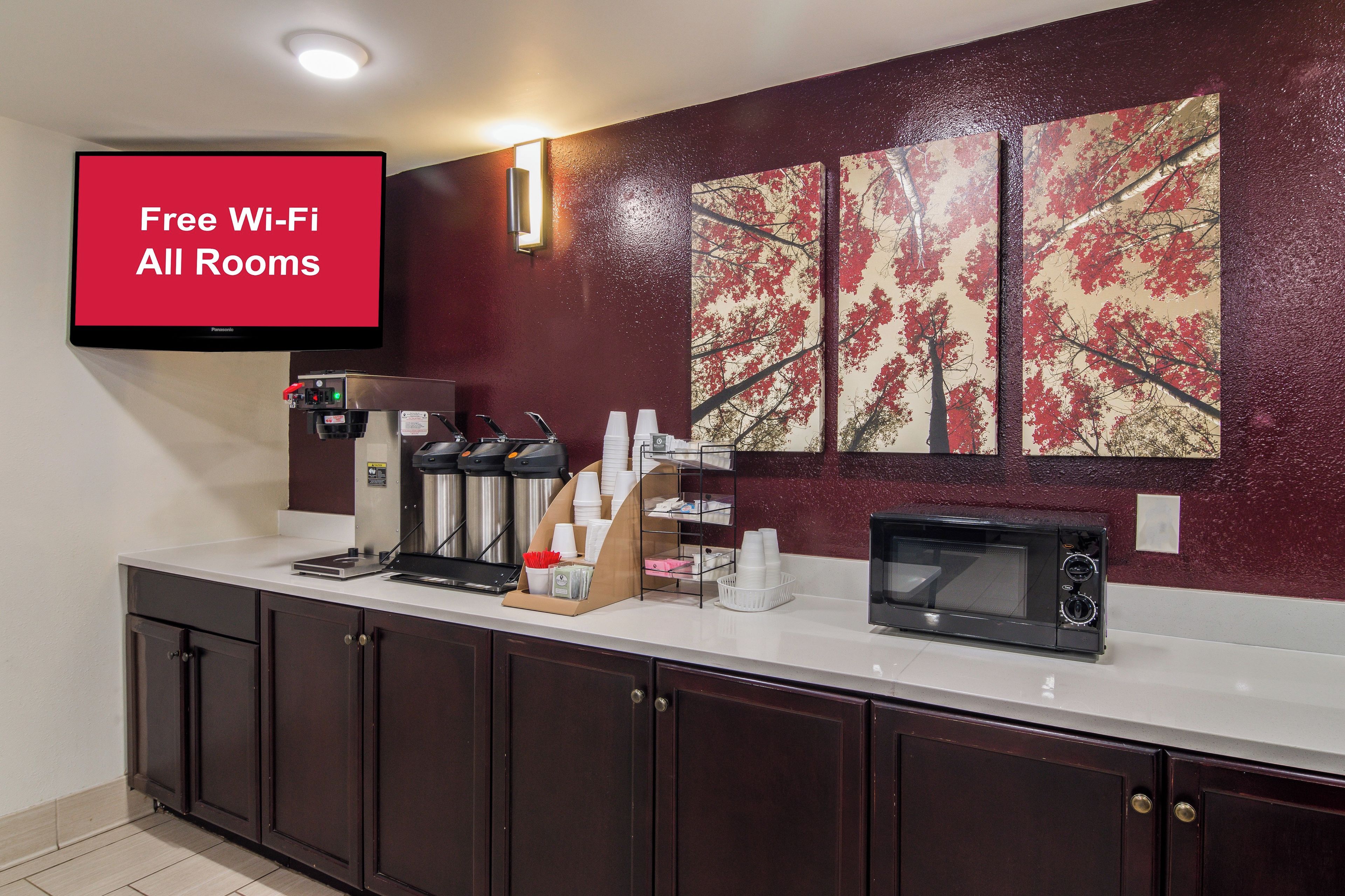 A kitchenette with a coffee machine, microwave, and a sign indicating free Wi-Fi in all rooms.
