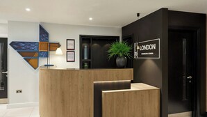 Ein Empfangsschalter mit modernem Design, mit Holzoptik und einer schwarzen Akzentwand.