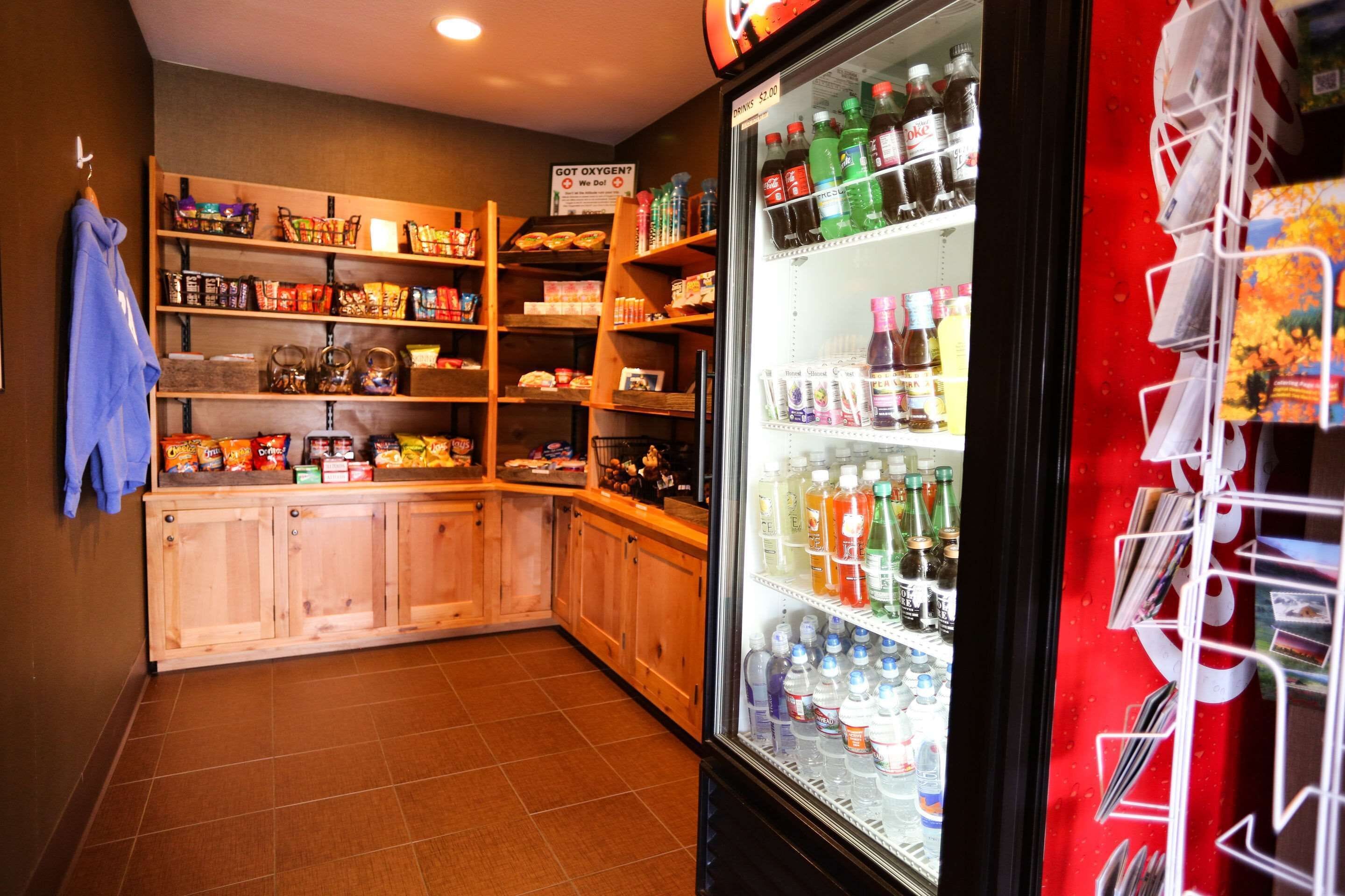 A snack bar with shelves stocked with various snacks and a refrigerated display case with beverages.