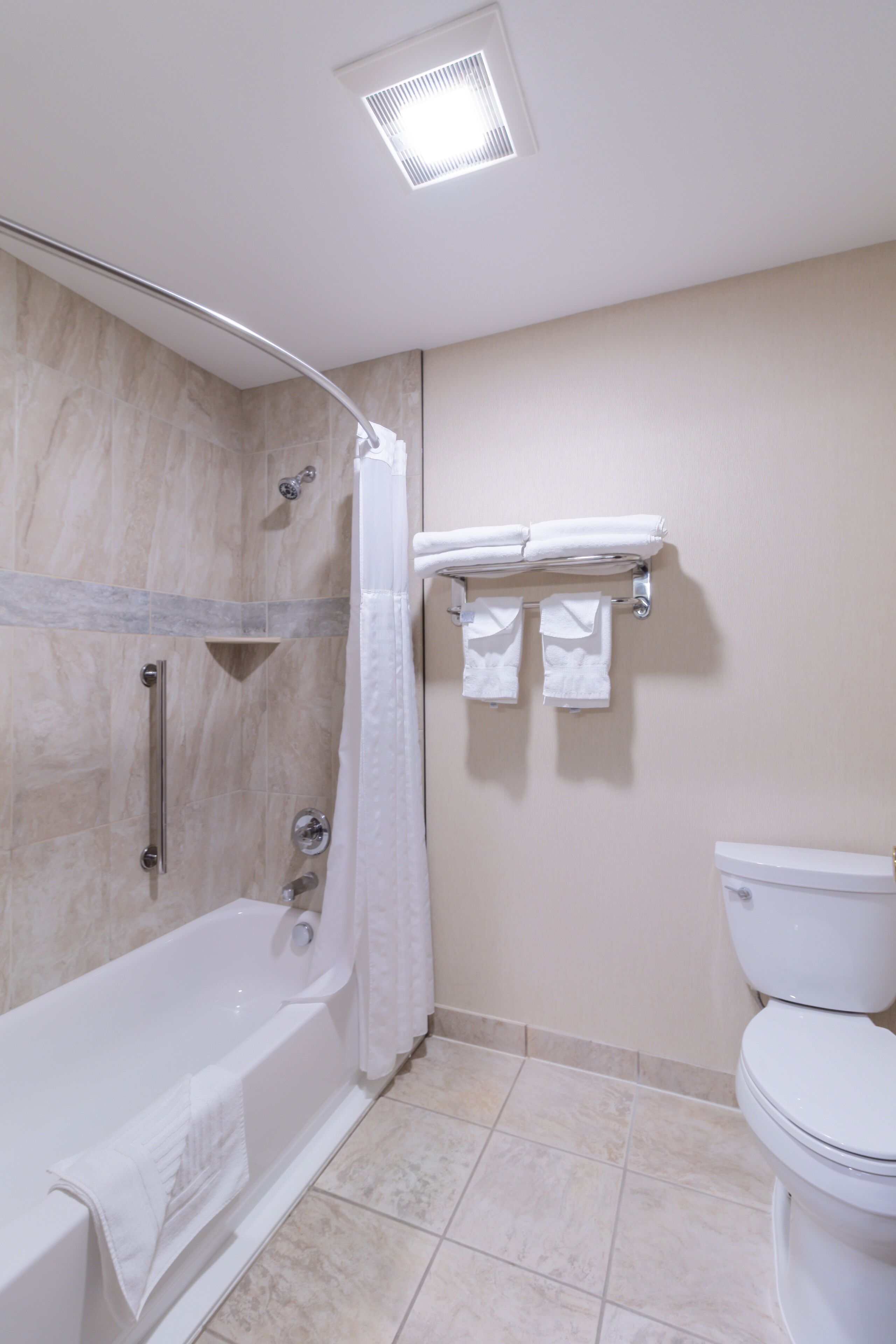 Une salle de bain équipée d’une baignoire, d’une douche, de toilettes et d’un porte-serviettes.