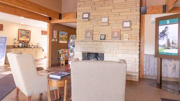 A spacious lobby with a fireplace, comfortable seating, and a chandelier.