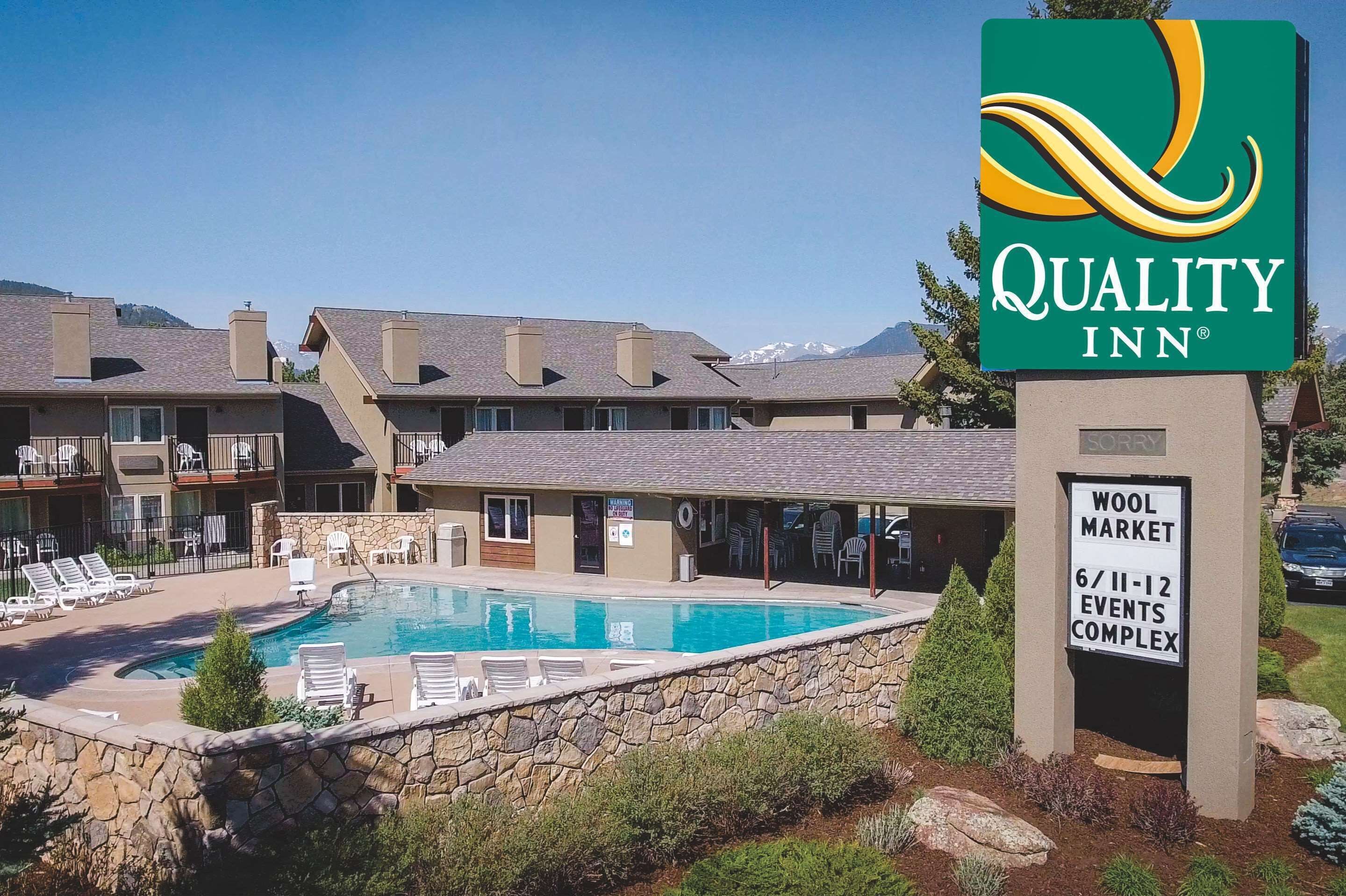A Quality Inn hotel with a pool area, lounge chairs, and a sign for the Wool Market Events Complex.