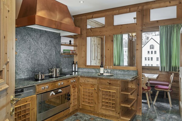 A kitchen with wooden cabinets, a stainless steel oven, and granite countertops.