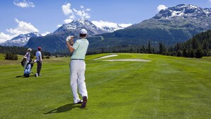 A golf course with a mountainous backdrop.