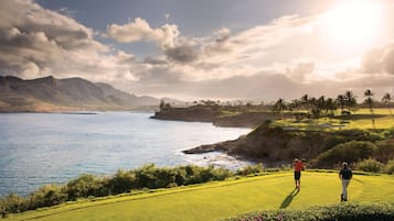 A golf course with a view of the ocean and mountains.