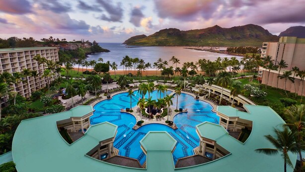 A resort with multiple swimming pools, a beach, and a mountainous backdrop. - The Royal Sonesta Kaua'i Resort Lihue (Lihue)