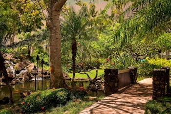 An outdoor dining area with tables set for a meal, overlooking the ocean. at The Royal Sonesta Kauai Resort Lihue