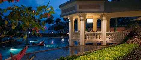 A pool area with a covered pavilion, palm trees, and well-maintained landscaping.