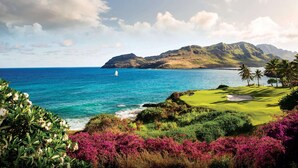A coastal landscape with a golf course, ocean, and mountains in the background. - The Royal Sonesta Kaua'i Resort Lihue (Lihue)