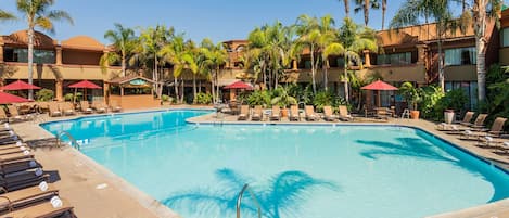 Alberca al aire libre, sombrillas en la alberca y camastros