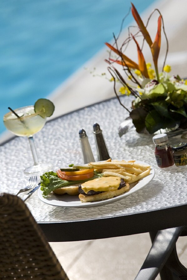 A table with a plate of food, a drink, and condiments.