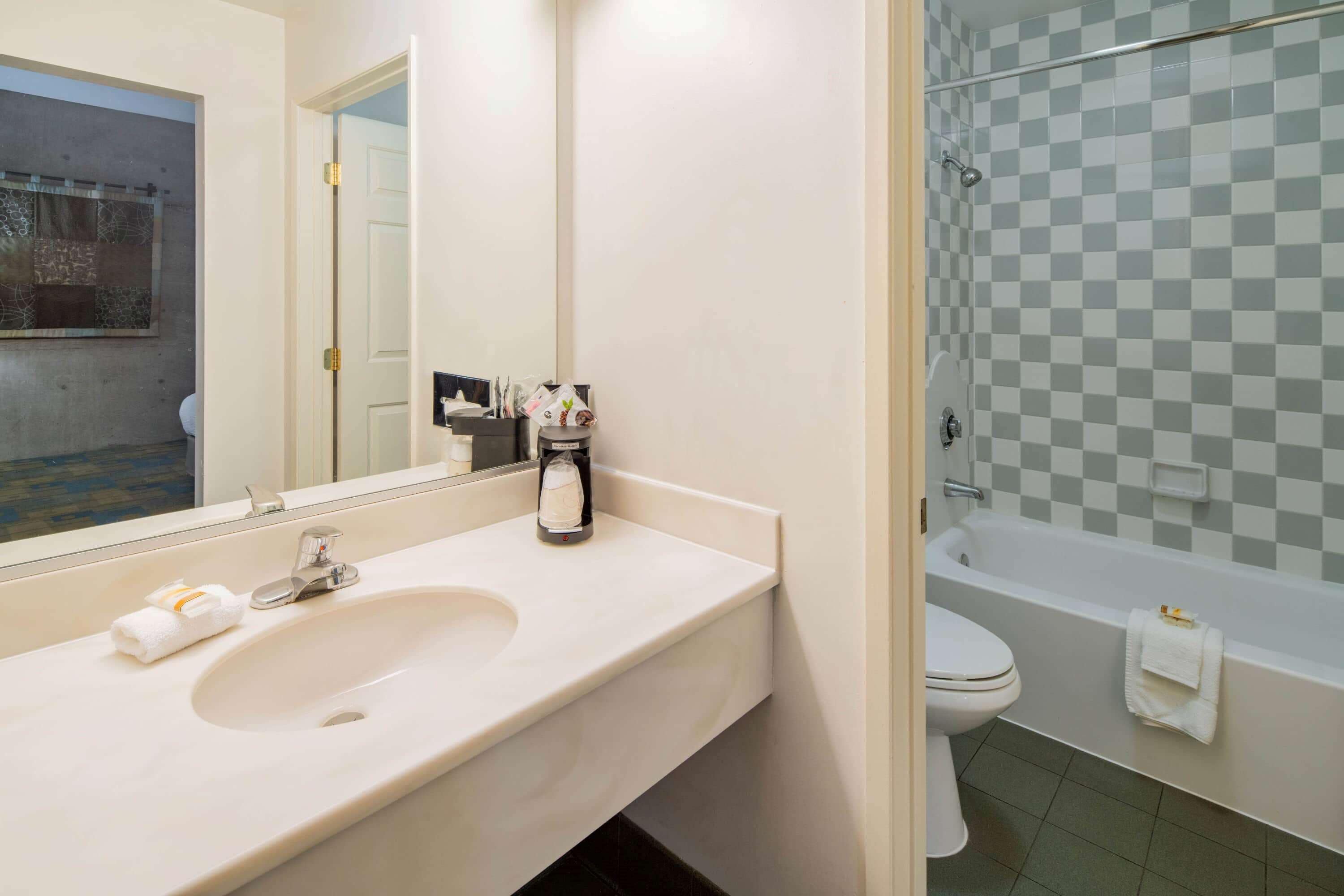 Une salle de bain équipée d’un lavabo, d’un miroir et d’un espace douche.
