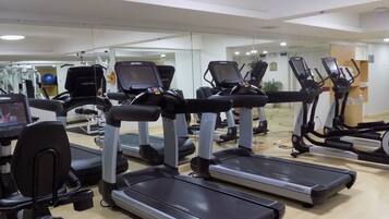 Un gimnasio con cintas de correr y equipo de ejercicio.