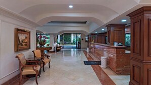Un vestíbulo con mostrador de recepción, zona de estar y vistas al exterior.