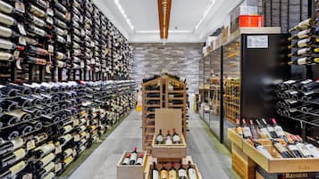 A wine cellar with rows of wine bottles on shelves and wooden crates in the center.